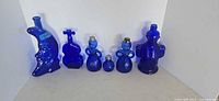 Front view of all six cobalt blue glass pieces lined up