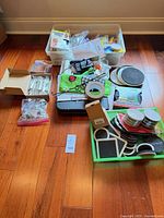 Overall lot view showing multiple containers of pads, hardware and packaged items