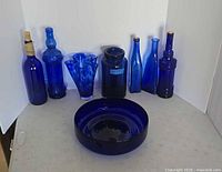 Front view of all eight cobalt blue glass pieces