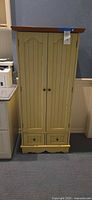 Full view of cream cabinet front with two doors and two drawers