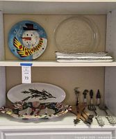 Overall view of both shelves showing plates, trays and utensils