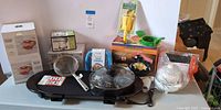 Full lot showing all boxed items, griddle/skillet, utensils and small appliances
