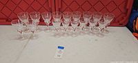 Full row of 15 clear stemmed cordial glasses