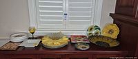 Wide view of entire sunflower dishware lot on sideboard