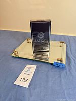 Sealed Versace Pour Homme box placed on mirrored tray with auction tag