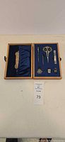 Open box showing all sewing tools in blue velvet interior