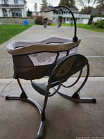 Full side view of Graco electric baby swing on metal frame