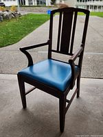 front three-quarter view of armchair showing blue seat cushion and wood frame
