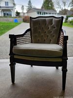 Front view of wooden armchair with green upholstery and cane sides