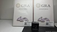 Two GRA Moissanite Report folders and earring display box