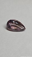 Pear-shaped faceted ametrine lying on side, table and crown facets visible