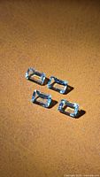 Four emerald cut aquamarines on brown surface