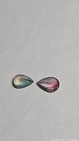 Both pear-cut tourmaline stones showing blue-pink coloration