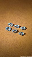 Six pear-cut aquamarines displayed on brown background (representative image)