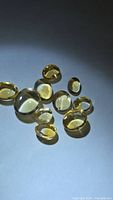 Group of 10 oval yellow citrine cabochons on neutral background