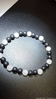 Full view of bracelet showing alternating black onyx and rose quartz beads