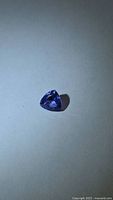 Trillion-cut violet-blue tanzanite on neutral background