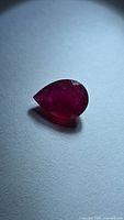 Pear-cut ruby on flat surface