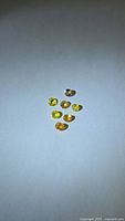 Seven small round faceted sapphires laid out on flat surface