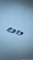 Pair of light lavender pear-cut sapphires on neutral background