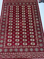 Full view of red Bokhara design rug showing entire pattern