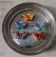 Top view of five mercury glass butterfly ornaments on tray