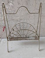 Front view of gold wire magazine rack showing atomic sunburst panel and overall structure