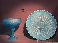 Blue pressed glass footed candy dish and scalloped plate displayed side by side