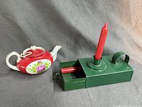 Candle holder and teapot side by side, showing overall forms and color