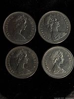 Obverse side of four Canadian dollar coins, portraits of Queen Elizabeth II visible