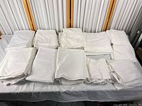 Overview of all folded white bed sheets on table