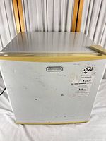 Front view of Emerson compact refrigerator showing brand badge, handle, label residue