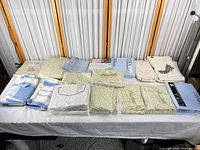 Full table view of assorted packaged sheets and dish towels