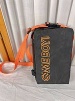 Front view showing orange GAME BOY logo and strap attachment