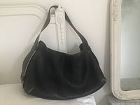 Front view of black leather purse showing overall design and shape