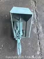 Front view of wall lantern showing patinated finish, open housing and two bulb sockets