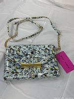 Front view of full bag showing print, flap, strap, and chain