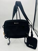 Front view of COOWONE dog walking bag hanging from stand with detachable treat pouch visible