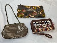 All three wallets and clutch laid out together