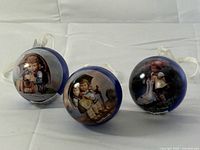 All three blue metallic Hummel ornaments standing on display