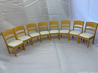 eight tan plastic chairs arranged in arc