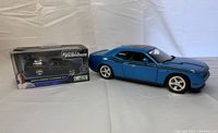 Both die-cast cars side by side, boxed Charger and unboxed Challenger