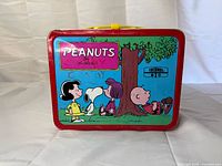 Front panel of Peanuts metal lunch box with Lucy, Snoopy, Charlie Brown artwork