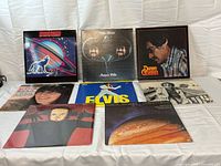 Group shot of 8 LP records laid out; covers visible for identification