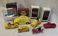 Overview of seven vehicle ornaments with three Hallmark boxes