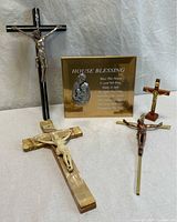 Group view of four crucifixes and one house blessing plaque