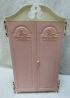 Front view of closed pink and ivory Susy Goose wardrobe showing logo and ornate top
