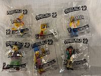 All six sealed figurines arranged, showing character names on bags