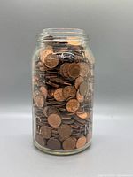 Full view of jar completely filled with pennies