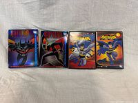 Front view of all four Batman DVD sets showing slipcase artwork and titles